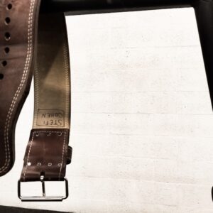 brown leather belt on white textile