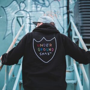 man in black hoodie standing on white metal ladder